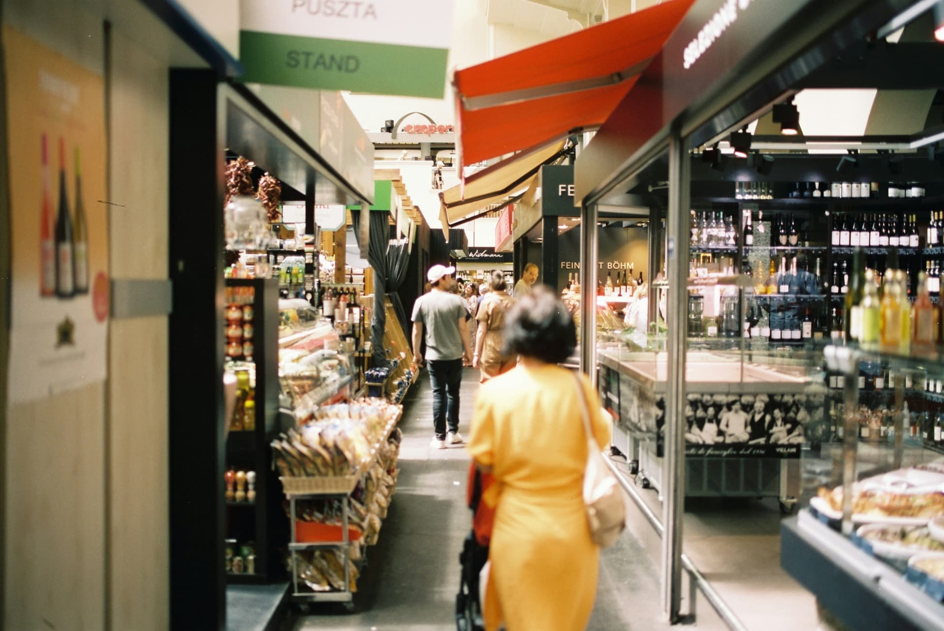People moving through a busy covered market aisle