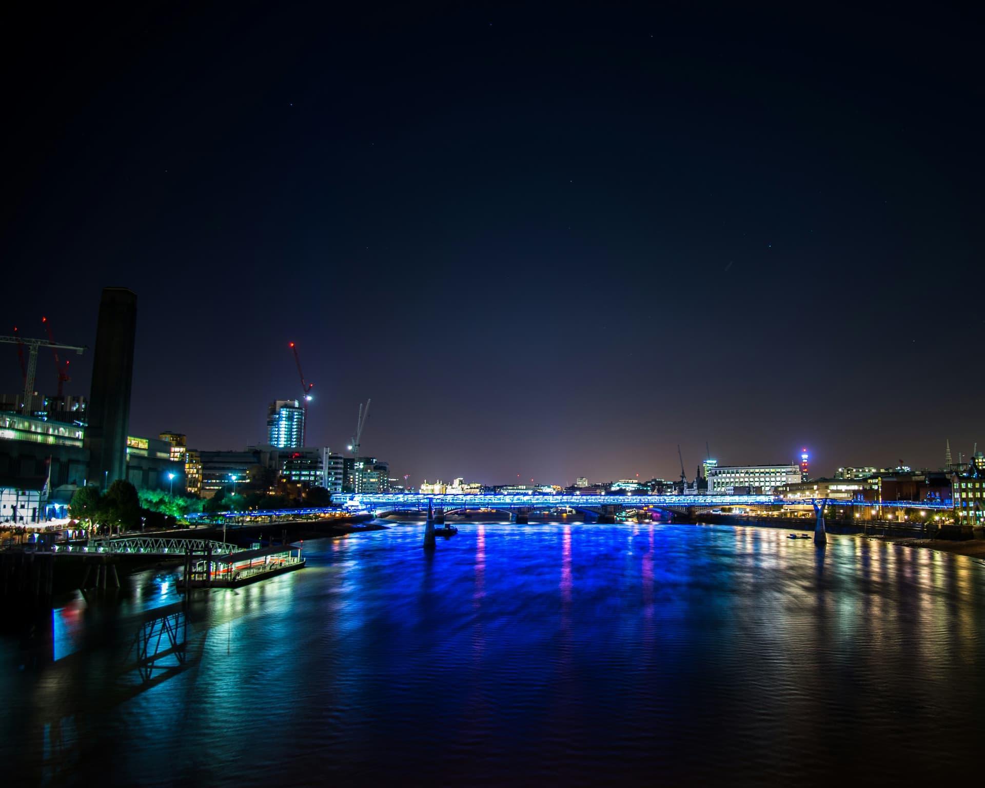 A cinematic city street illuminated by lights after dark