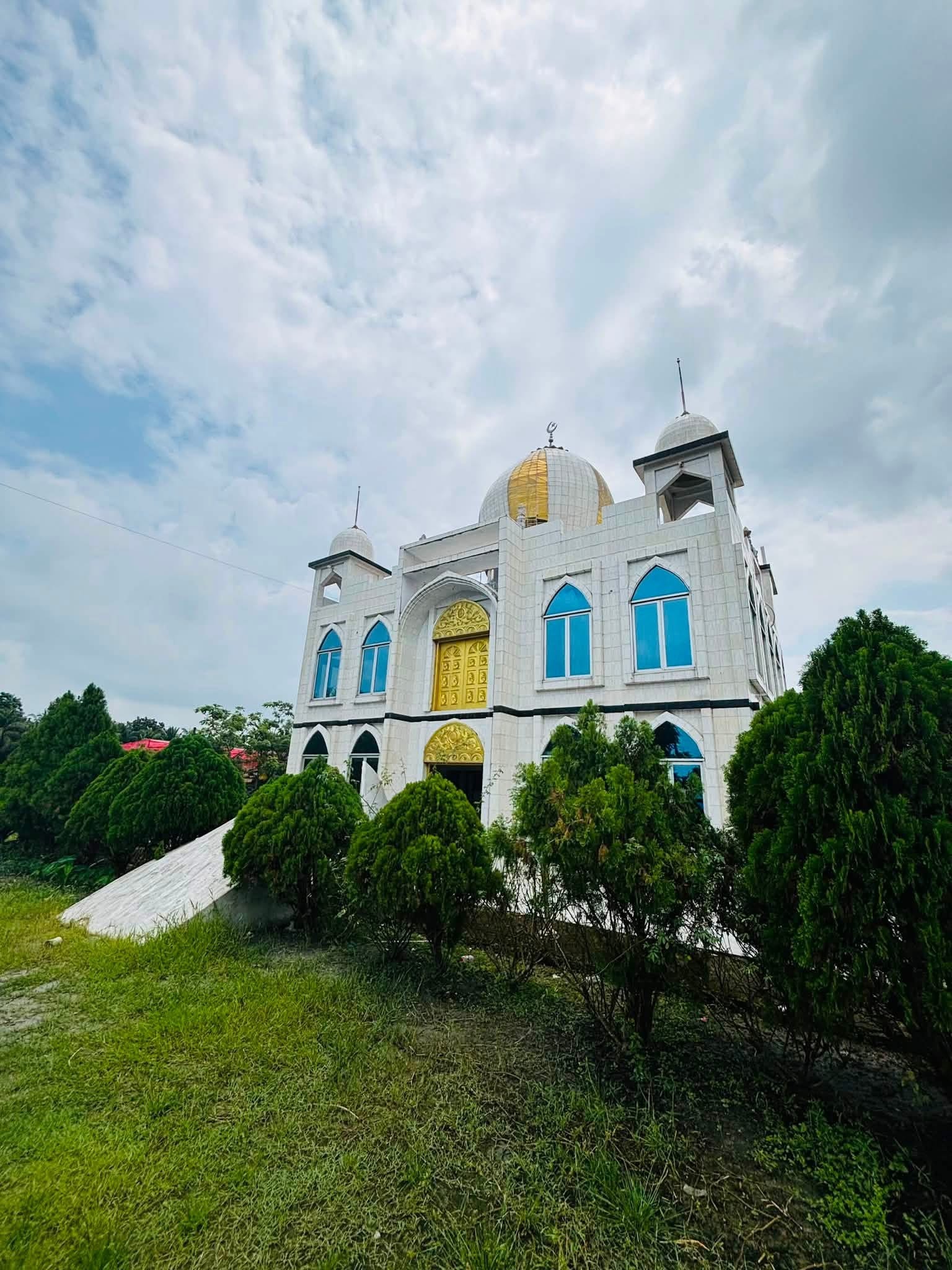 A white mosque standing in green countryside