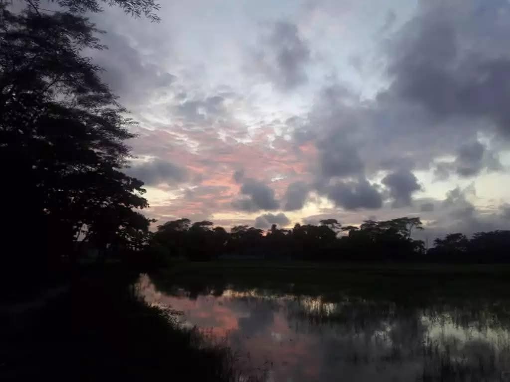 A quiet river beneath a soft sunset sky