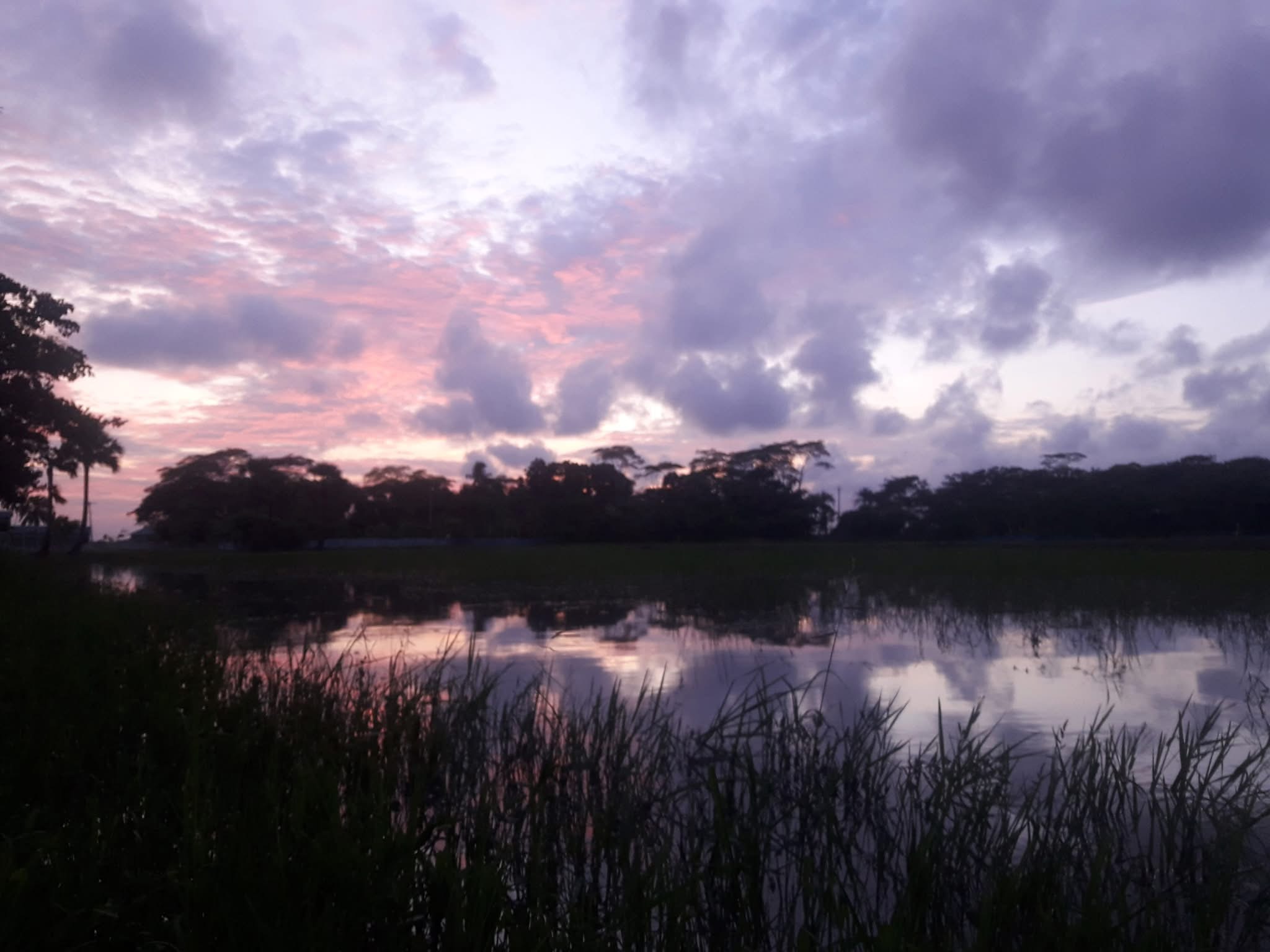 Clouds reflected in calm water at sunset