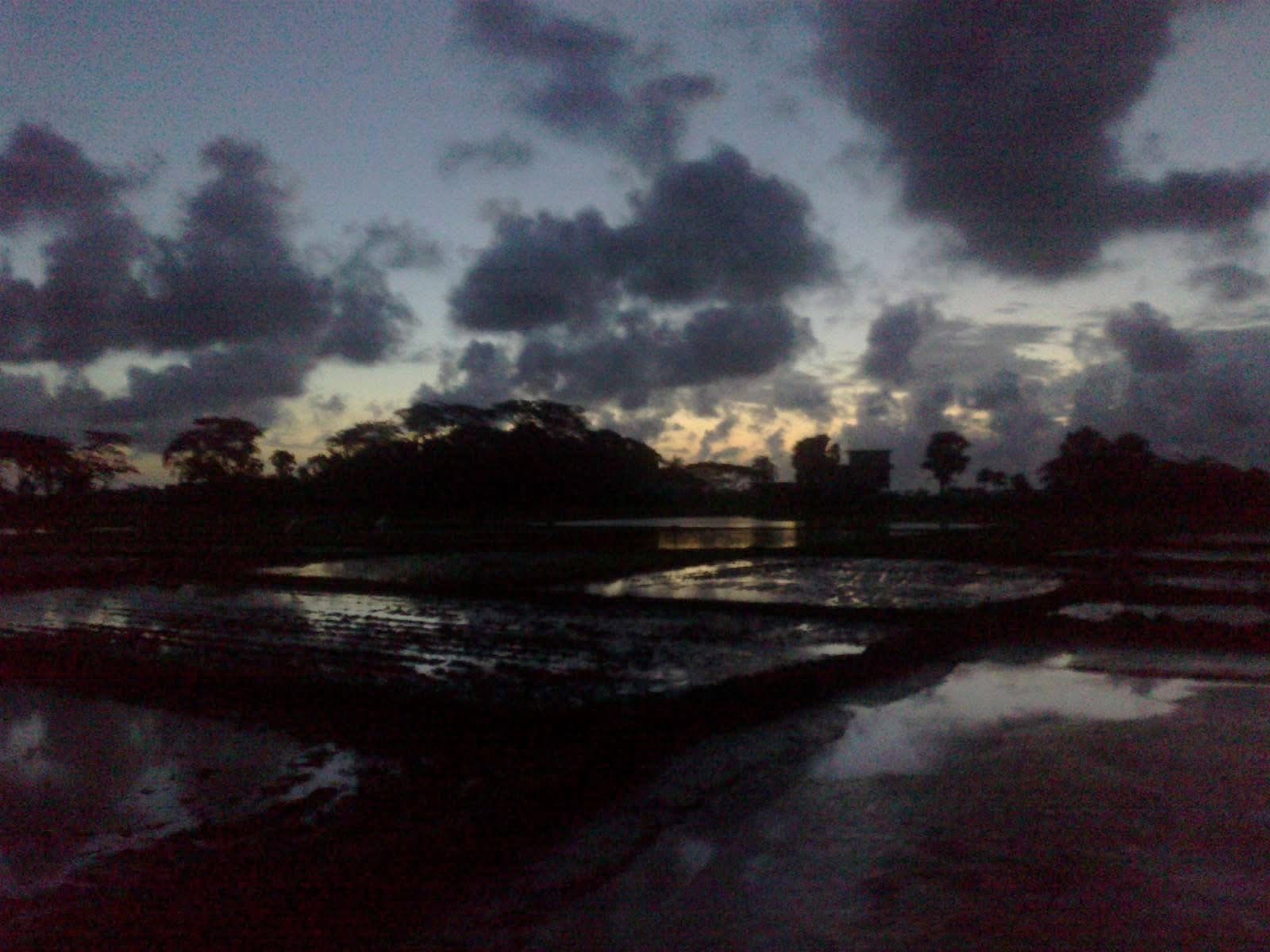 Dark storm clouds over a river at dusk