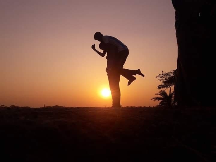 A person jumping in silhouette against the setting sun